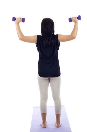 Back view of woman lifting dumbbells isolated on whiteの写真素材
