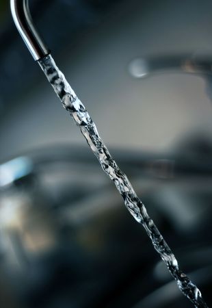 Flowing water stream through a faucet.の写真素材