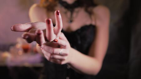 Woman is wearing a black corset dress. Hand reaches forward.の写真素材