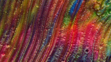 Background of gold dust in a silvery mist with blue, yellow and red streaks.