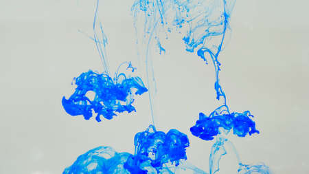 Drops of blue paint dissolved in the water space.