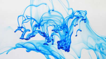 Drops of blue paint dissolved in the water space.の写真素材