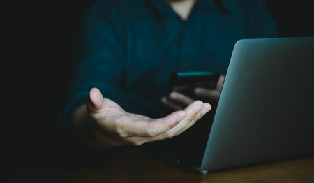 Man hand using smart phone and laptop computer with blank screen for your text.の写真素材