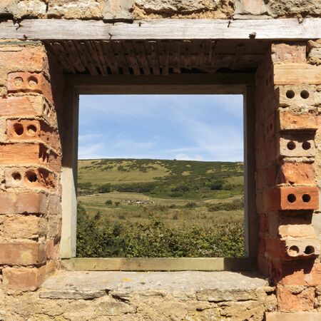 The Dorset countryside through the window of the gardener's house in the ghost village of Tyneham,...