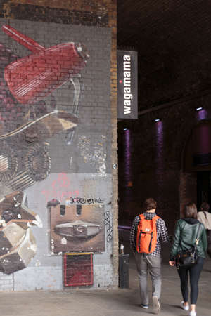 Couple walking into the Clink Bridge Tunnel, Southwark, London, London, England, United Kingdom