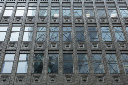 30 St Mary Axe (The Gherkin) reflected in the windows of Holland House, City of London, England,...