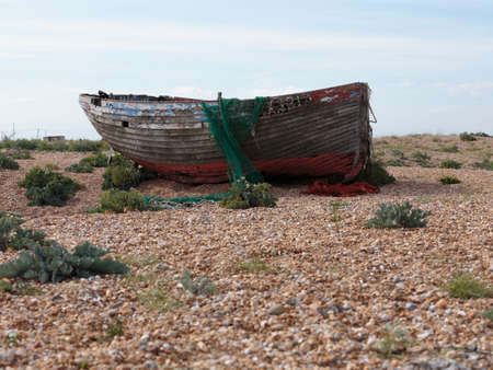 The hull of an abandoned fishing boat on Dungeness beach, a headland on the coast of Kent, England, formed largely of a shingle beach.の写真素材