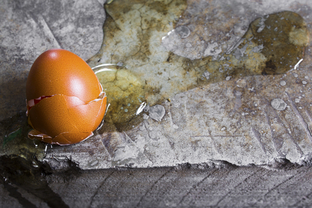 Eggs are broken on cement floor with copy space.の写真素材