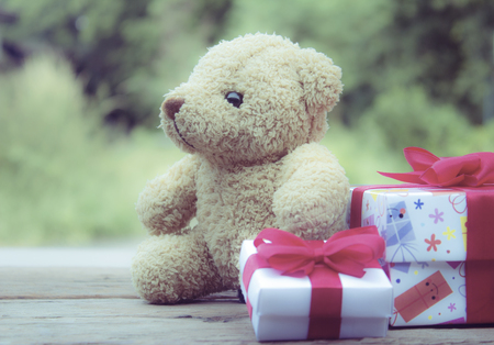 Cute teddy bear with gift box on old wood background,Christmas and New Year's Day concept,vintage style.の写真素材