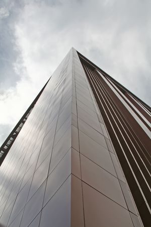 A commercial building pointing towards the grim sky.