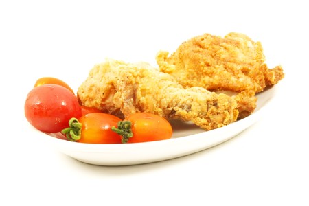 Fried Chicken with Tomatos on a White Plateの写真素材