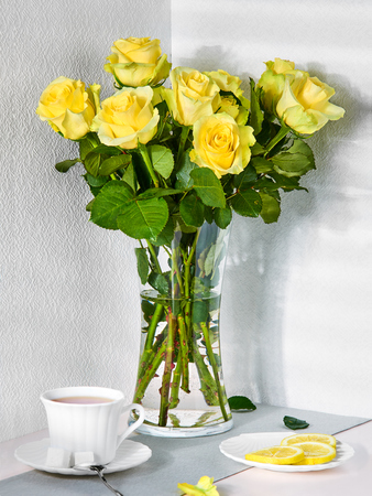 Still life with a bouquet of yellow roses and a Cup of teaの写真素材
