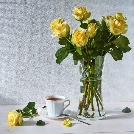 Still life with a bouquet of roses and a Cup of teaの写真素材