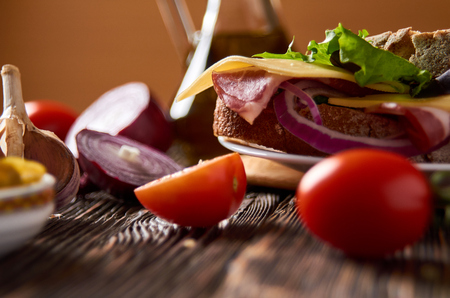 Sandwich with bacon, cheese, garlic, jalapeno pepper and herbs on a plateの写真素材