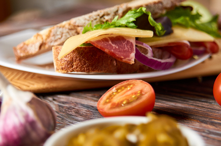 Sandwich with bacon, cheese, garlic, jalapeno pepper and herbs on a plateの写真素材