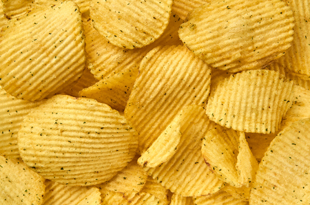 Background of juicy corrugated rounded potato chips close-upの写真素材