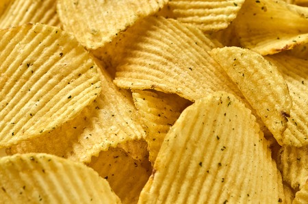 Background of juicy corrugated rounded potato chips close-upの写真素材
