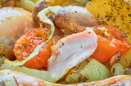 Baked roast chicken legs with tomatoes, onions, potatoes, mushroomsの写真素材