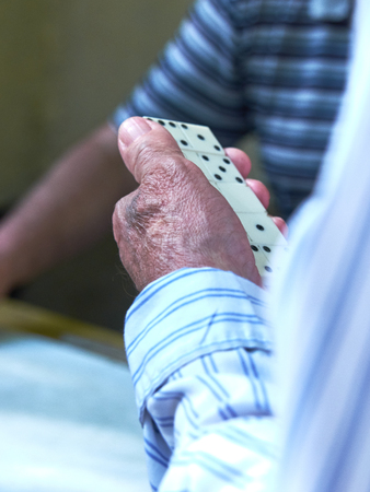 top view of the hands of adults playing dominoesの写真素材