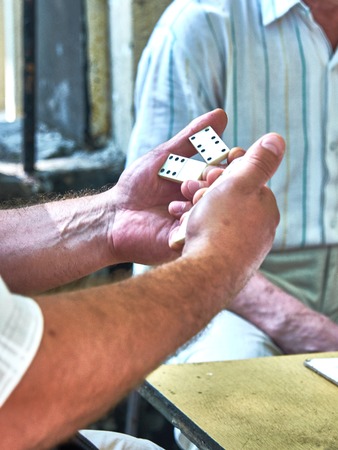 top view of the hands of adults playing dominoesの写真素材