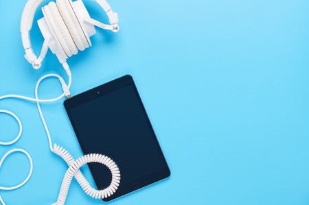 top view upon gadgets on blue background, composition of headphones and tabletの写真素材