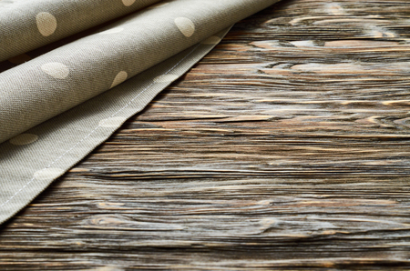 Old dark wooden background. Wooden table with grey polka dot kitchen towelの写真素材