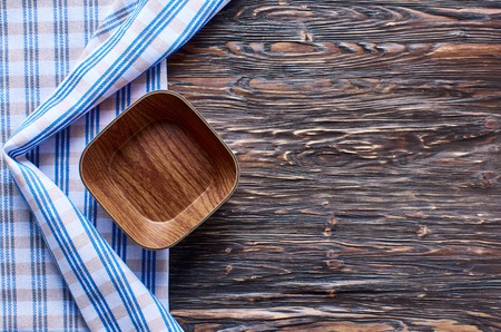 Old dark wooden background. Wooden table with blue kitchen towels in a cageの写真素材