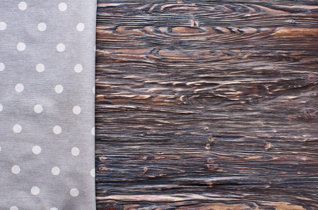 Old dark wooden background.Wooden table with grey polka dot kitchen towelの写真素材