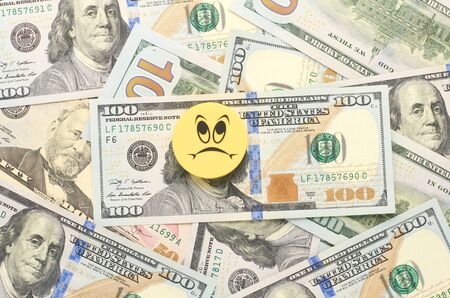 Background from chaotically lying of notes for one hundred dollars. In the foreground, a...