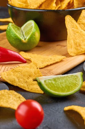 Nachos - yellow corn chips with various sauces in bowls: guacamole, cheese sauce, white sauce, on dark background. Mexican food concept.の写真素材