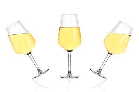 Three glasses of white wine isolated on white background. Glasses tilted in different directions, poured completely.の写真素材
