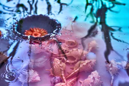 Raindrops fall on the surface of the water. The circles from the raindrops on the water surface. Abstract color background of circles on the water and falling drops.の写真素材