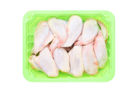 Fresh chicken wings in green plastic packaging, isolated on a white background. The view from the top.の写真素材