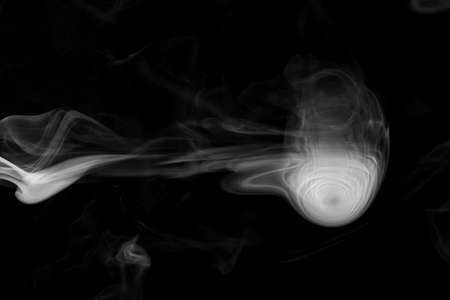 Clouds of white smoke on a black background, movement of smoke on a black background, clouds of smoke in the shape of a jellyfish, smoky background, abstract smokeの写真素材