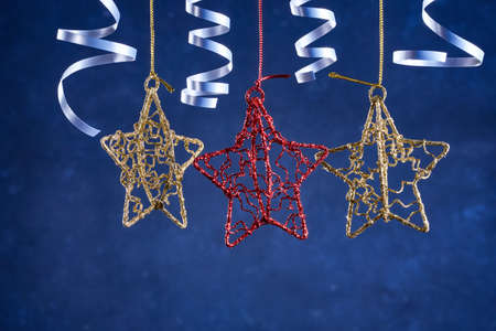 Christmas background with gold and red stars and silver confetti ribbons. New year's background with free space for text.の写真素材