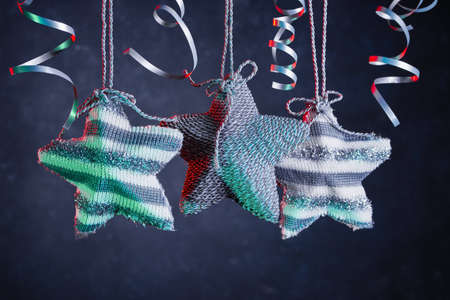 Christmas background with silver knitted stars and silver confetti ribbons. New year's background with free space for text.の写真素材