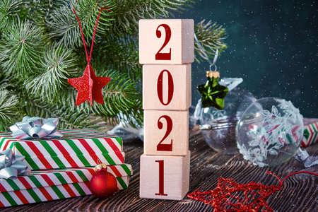 Cubes with numbers 2021 on a Christmas background with gifts in boxes, Christmas decorations and a decorated spruce branch. Christmas backgrounds with free space for text.の写真素材