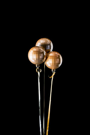 A bouquet of Golden Christmas balloons isolated on a black background. New year's background, free space for text.の写真素材