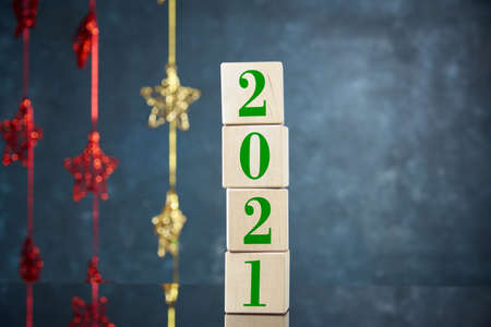 Four cubes standing on top of each other with the numbers 2021 on the background of Christmas decorations. New year's background, free space for text.の写真素材