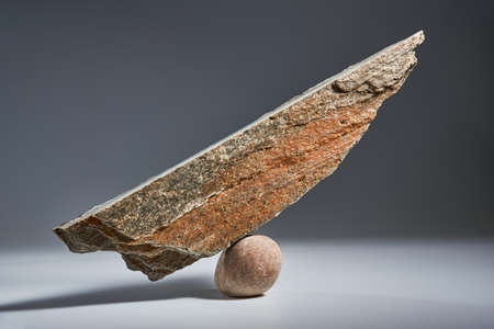 Balancing pyramid of sea pebbles on a gray background, the concept of harmony and balance, heavy and light. Stones in the form of scales with balancing stones.の写真素材