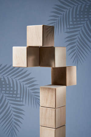 Balancing pyramid of wooden square blocks on a blue background, the concept of harmony and balance, heavy and light.の写真素材