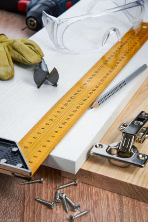 Installation of furniture hinges in the chipboard, tools and accessories needed to perform the work. Small carpentry work at home, the concept of a home master, self-repair of the houseの写真素材