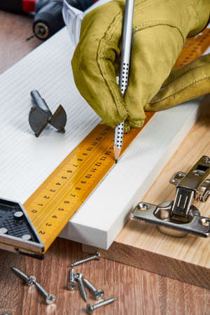 Installation of furniture hinges in the chipboard, tools and accessories needed to perform the work. Small carpentry work at home, the concept of a home master, self-repair of the houseの写真素材