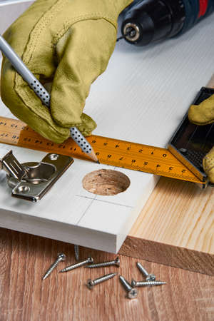 Installation of furniture hinges in the chipboard, tools and accessories needed to perform the work. Small carpentry work at home, the concept of a home master, self-repair of the houseの写真素材