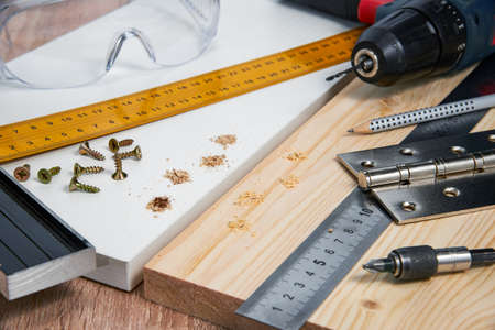 Installation of furniture hinges in the chipboard, tools and accessories needed to perform the work. Small carpentry work at home, the concept of a home master, self-repair of the houseの写真素材
