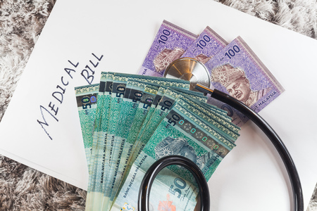 Stethoscope with wording of "Medical Bill" showing expensive healthcare or expensive medical bill with Malaysia Ringgit Bank Notesの写真素材