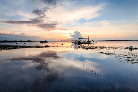 Holiday in Bali, Indonesia - Reflection Sunrise in Tanjong Benoa with boatの写真素材
