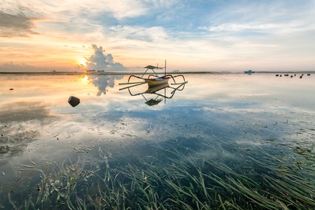 Holiday in Bali, Indonesia - Reflection Sunrise in Tanjong Benoa with boatの写真素材