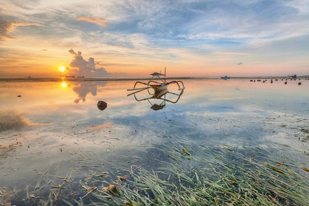 Holiday in Bali, Indonesia - Reflection Sunrise in Tanjong Benoa with boatの写真素材