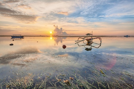Holiday in Bali, Indonesia - Reflection Sunrise in Tanjong Benoa with boatの写真素材